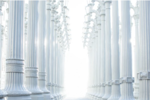 Row of tall decorative street lamp posts in a bright, vanishing-point corridor.